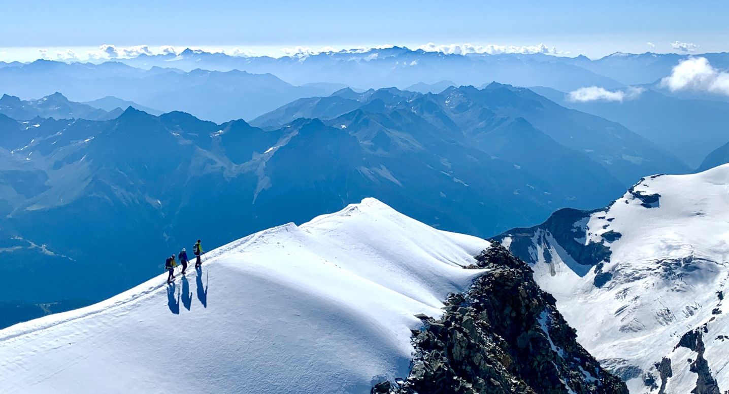 Eine Gruppe auf dem Gipfel eines Berges während einer Hochtour in Südtirol